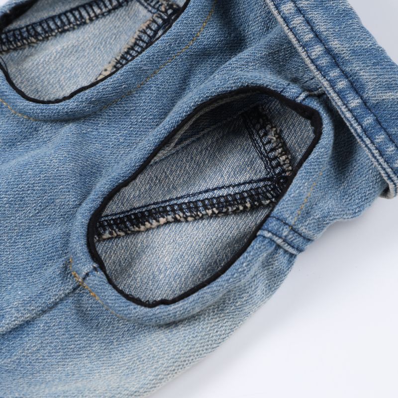 Close-up of blue denim fabric with stitching detail on a white background
