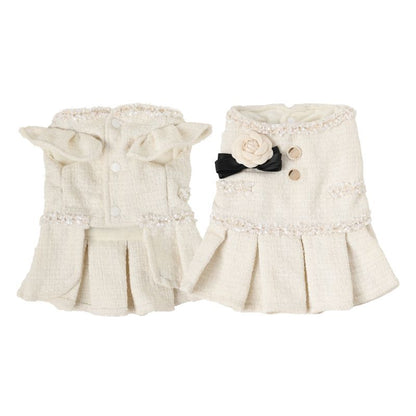 Pair of cream-colored pet tweed dress with decorative elements on a white background