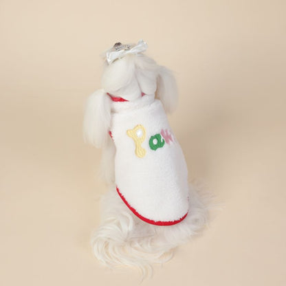 White dog dress with colorful letters on a beige background