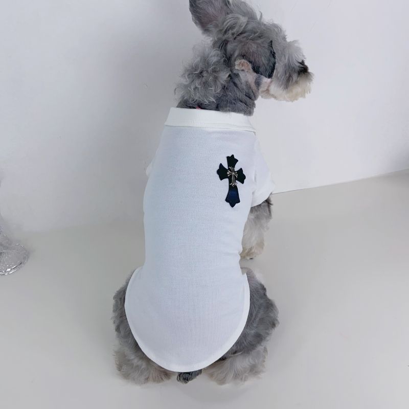 Small dog wearing a white chrome hearts polo tee with a black cross design on a white background