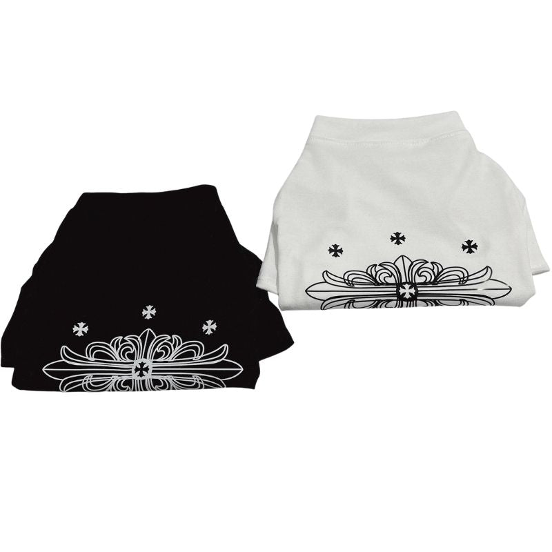 Two folded Chrome Hearts pet shirts, one black and one white, with decorative patterns on a white background.