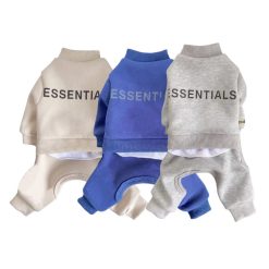 Three dog sweaters in beige, blue, and gray with 'ESSENTIALS' branding on a white background.