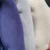 Close-up of three different textured fabrics in blue, gray, and beige.
