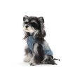 Dog wearing a denim outfit on a white background
