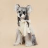 Stuffed dog toy with a bow on a beige background
