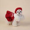Small white dog wearing a red knitted outfit with a bow on a beige background