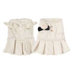 Pair of cream-colored pet tweed dress with decorative elements on a white background