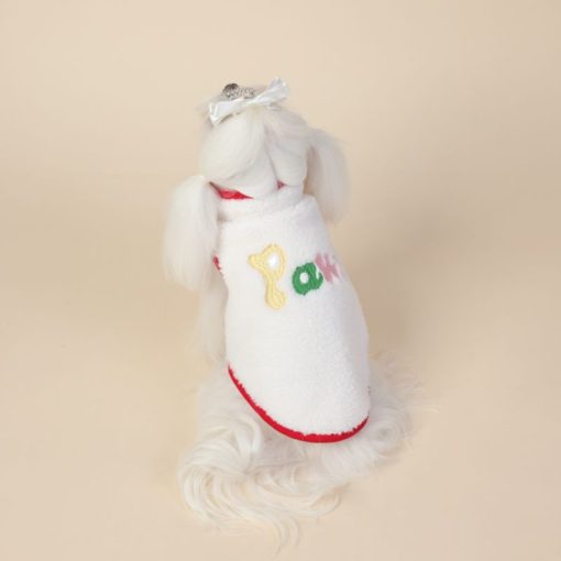 White dog dress with colorful letters on a beige background