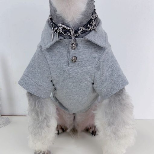 Dog wearing a gray chrome heart polo with a white background