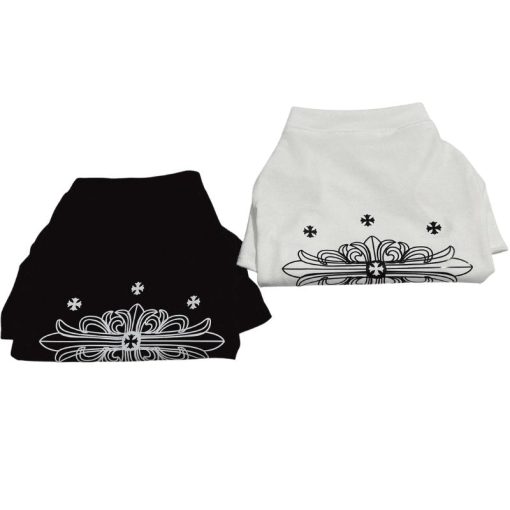 Two folded Chrome Hearts pet shirts, one black and one white, with decorative patterns on a white background.